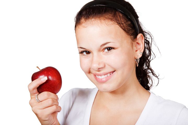 Chica delgada con una manzana roja